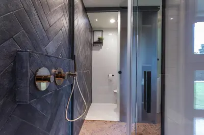 a bathroom with a shower with a glass door at Bed & Breakfast Nummer5 in Heusden - Zolder