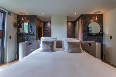 a bedroom with a large bed with two mirrors at Bed & Breakfast Nummer5 in Heusden - Zolder