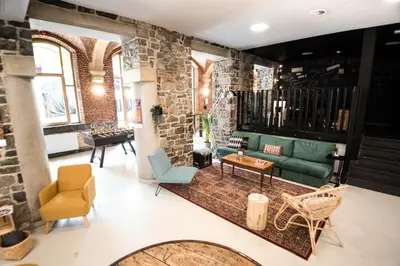 a living room with a green couch and chairs at HI Liège Hostel in Liège