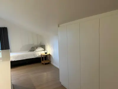 a white bedroom with a bed and a closet at Vakantiewoning Laurijn in Bilzen
