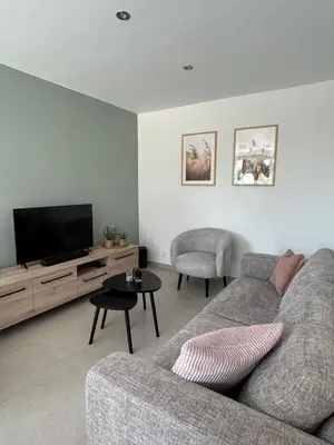 a living room with a couch and a flat screen tv at Vakantiewoning Laurijn in Bilzen