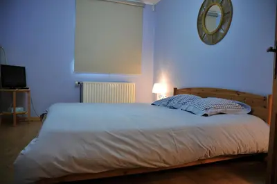 a bedroom with a large bed with a blue light at La Source du Broly in Soumagne