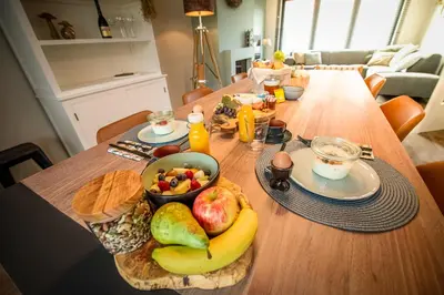 a wooden table with a bowl of fruit on it at Huize Idalie in Bilzen