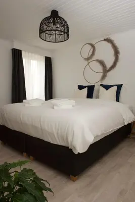 a bedroom with a large white bed with blue pillows at Vakantiewoning Oudsbergen in Oudsbergen