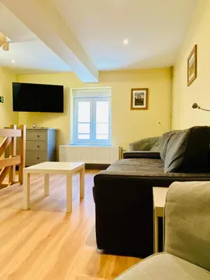 a room with a bed and a tv and a table at Les gîtes du Broukay - Alouette in Bassenge