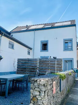 a table and chairs in front of a white building at Les gîtes du Broukay - Alouette in Bassenge