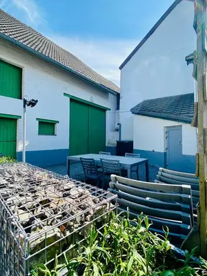 a patio with a table and chairs and buildings at Les gîtes du Broukay - Hirondelle in Bassenge