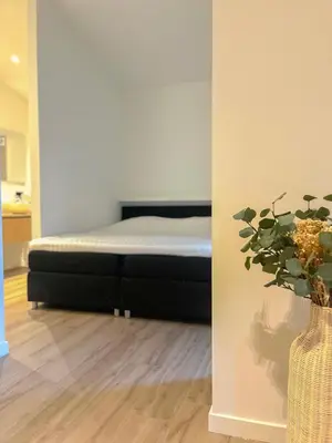 a bedroom with a bed and a vase with a plant at de Bosch in Lummen