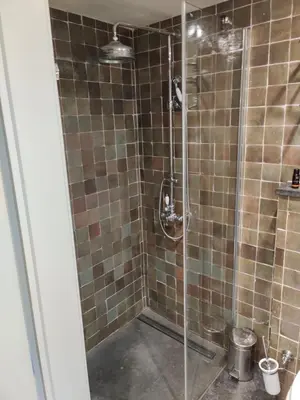 a shower with a glass door in a bathroom at de Bosch in Lummen