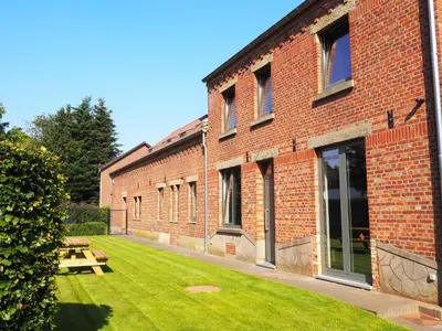 a brick building with a picnic table in the yard at Huis Berenbroek in Genk