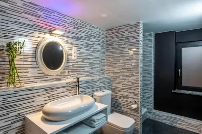 a bathroom with a white toilet and a mirror at Maison Noppius - Love Hotel in Liège