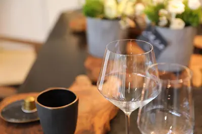 two wine glasses sitting on top of a wooden table at Ellé'Belle Oudsbergen 1-, 2- or 3-Bedrooms in Oudsbergen