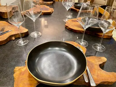 a black plate and wine glasses on a table at Ellé'Belle Oudsbergen 1-, 2- or 3-Bedrooms in Oudsbergen