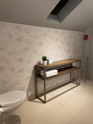 a bathroom with a toilet and a shelf with towels at B&B Bloonwinning in Hasselt