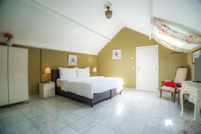 a bedroom with a bed and a table and a chair at Vakantie Logies de Kleine Motte in Sint-Truiden