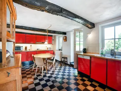 a kitchen with red cabinets and a table and chairs at Voeren Mansion with Garden in Voeren