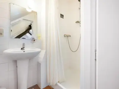 a white bathroom with a sink and a shower at Voeren Mansion with Garden in Voeren