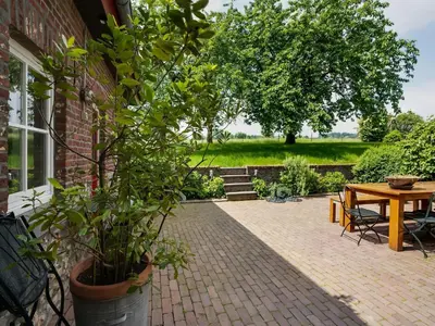 a patio with a table and a potted plant at Voeren Mansion with Garden in Voeren