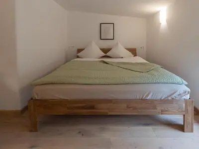 a bedroom with a bed with a wooden bed frame at Bellerose Maison de Greunebennet in Plombières