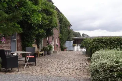a cobblestone walkway in front of a house at Hoeve Espewey Cottage in Hombourg