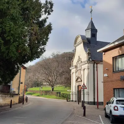 a church with a steeple on the side of a street at Kanne: charming house between nature and shopping in Kanne