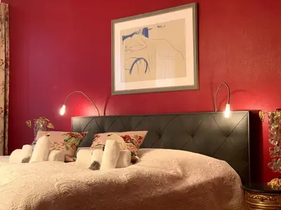 a bedroom with a bed with red walls at Gite de Caractère Le Lys Bleu in Limbourg