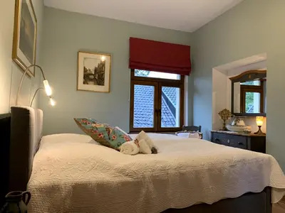 a bedroom with a bed with two stuffed animals on it at Gite de Caractère Le Lys Bleu in Limbourg