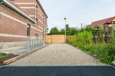 a group of ducks sitting on a sidewalk next to a building at Het Dorpshuys - vakantiewoning tot 12 personen in Maaseik