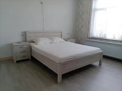 a bedroom with a white bed and a window at Moodraz vakantiehuis centrum Peer in Peer