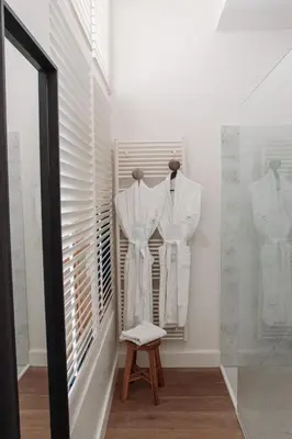 a dressing room with white shirts and a stool at B&B Maison Mairie Hasselt in Hasselt