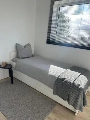 a white bedroom with a bed and a window at Domum in Dilsen-Stokkem