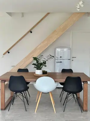 a dining room with a wooden table and black chairs at Domum in Dilsen-Stokkem