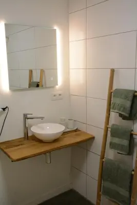 a bathroom with a white sink and a mirror at Vakantiewoning Het Wielje Maasland in Kinrooi