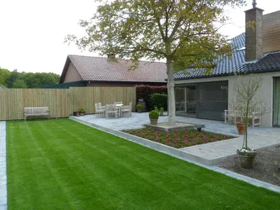 a backyard with a lawn with a bench and a tree at Bosrand81 in Hechtel