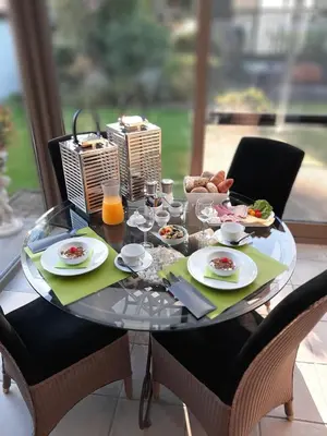 a glass table with food and drinks on it at B&B Cosiness in Balen