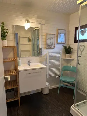 a bathroom with a sink and a mirror and a chair at Chalet Happiness in Zutendaal