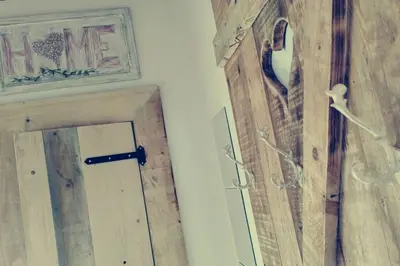 a wooden door with a mirror and a picture on a wall at ländlich & gemütlich in Raeren mit 2 Schlafzimmern in Raeren