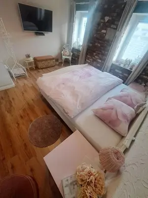 a large bed in a room with a table at ländlich & gemütlich in Raeren mit 2 Schlafzimmern in Raeren
