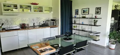 a kitchen with a glass table and white cabinets at Les Croisettes 88, design loft XXL with amazing vue for peaceful stay in Trooz