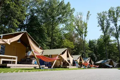 a group of tents with a hammock in front at Glamping Belgisch Limburg in Oudsbergen