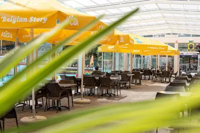 a restaurant with tables and chairs and umbrellas at Glamping Belgisch Limburg in Oudsbergen
