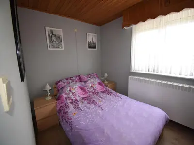 a bedroom with a purple bed and a window at Elegant & Peaceful Holiday Retreat in Peer in Peer