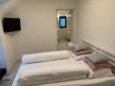 a white room with two beds and a mirror at Nummer 151 villastudios in Hasselt