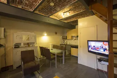 a kitchen with a table and a tv in a room at Apartments Cour d'Aix in Richelle