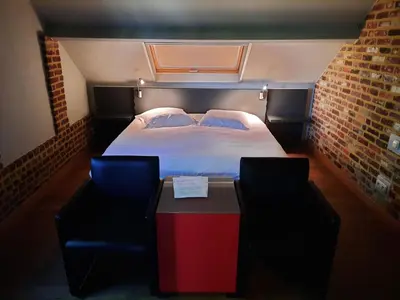 a bedroom with a bed and a table and chairs at B&B Kerkevelde in Bilzen