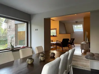 a dining room and living room with a table and chairs at Sterrenheide in Heusden - Zolder