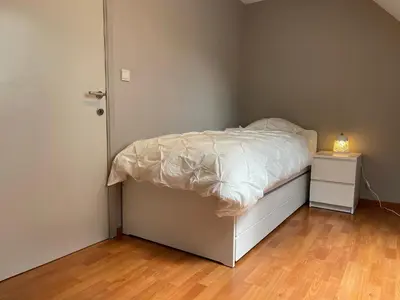 a small bedroom with a bed and a night stand at Sterrenheide in Heusden - Zolder