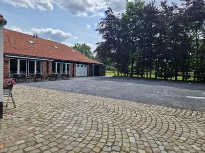 a cobblestone driveway in front of a building at B&B De Kroonhoeve in Beringen