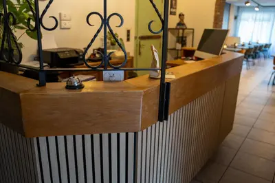 a reception desk in a store with a laptop on it at Hotel Monika in Zutendaal