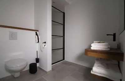a bathroom with a toilet and a glass shower at 't pure genot in Dilsen-Stokkem